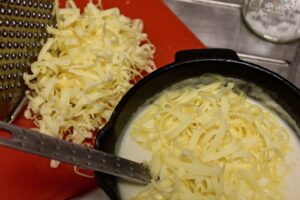 Cheese being added to the white sauce