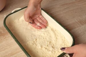 pressing shortbread mixture with fingers in tray