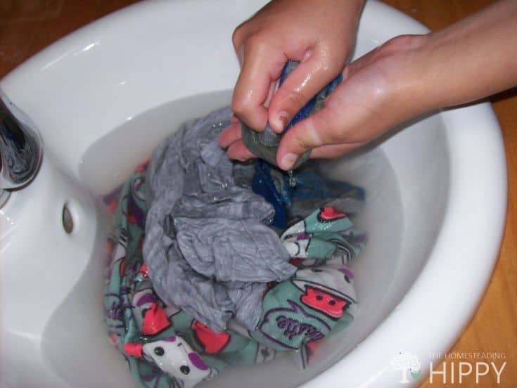 washing clothes by hand in kitchen sink