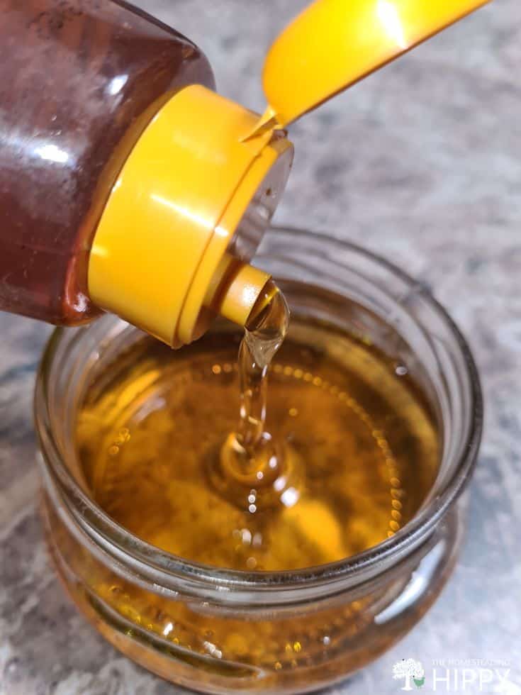 decanting honey into glass jar