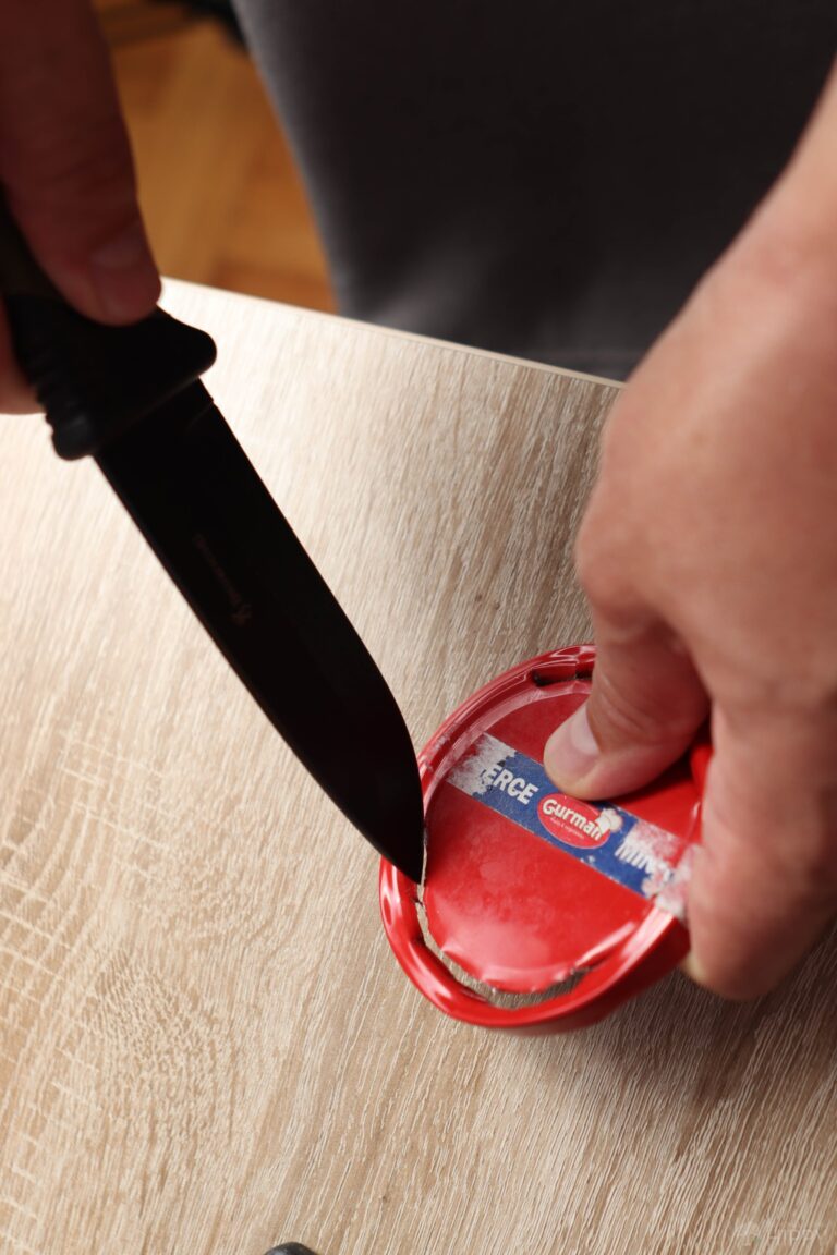 cutting out a circle from a lid with knife