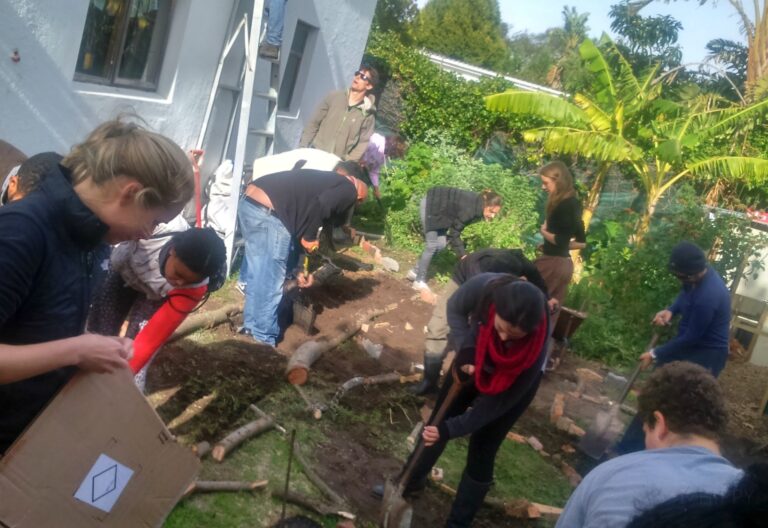 permaculture students mulching in a home garden