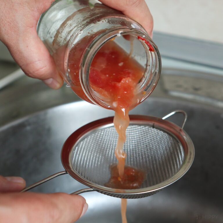 straining tomato seeds from the fermented tomato pulp