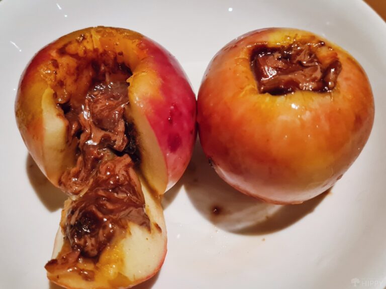 two baked chocolate filled apples on a plate