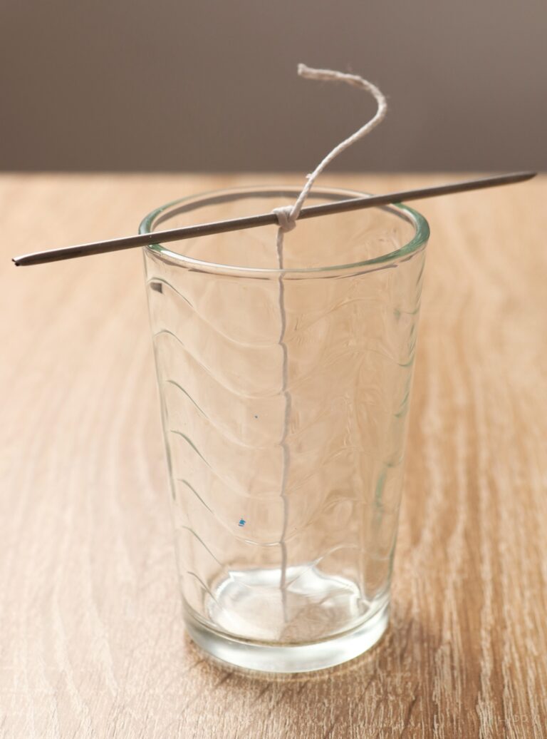 piece of string wrapped around metal rod on top of glass