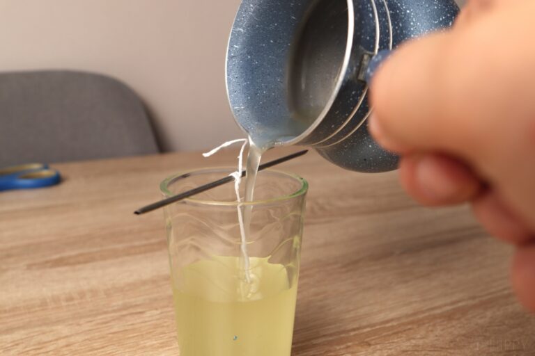pouring melted tallow into candle container