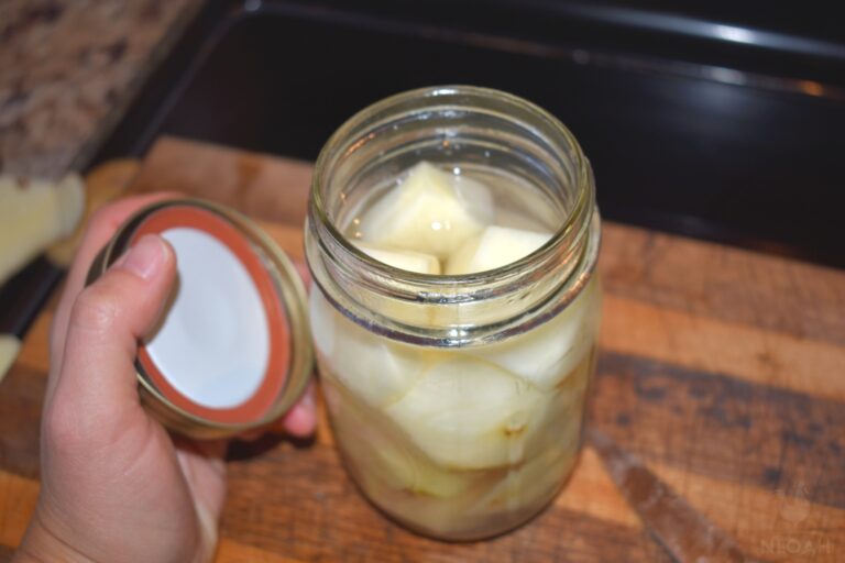 putting lid on jar filled with potato chunks and hot water