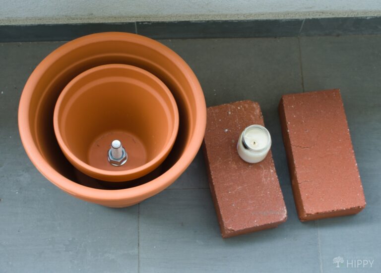 terracotta pots inside one another next to two bricks