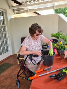 woman in wheelchair adding soil to plant pots