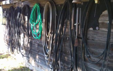 irrigation hoses hung on outside wall